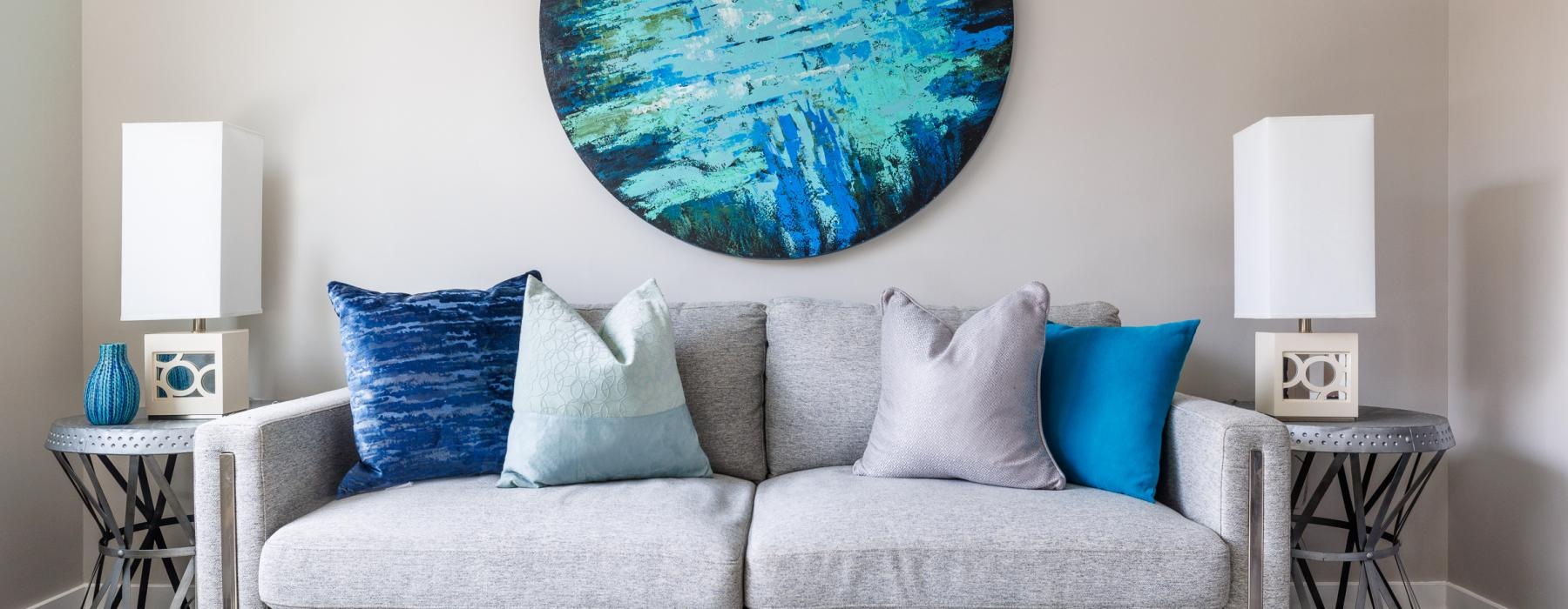 a couch with pillows and a globe on the wall
