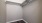 a walk-in closet with white walls and a metal bar